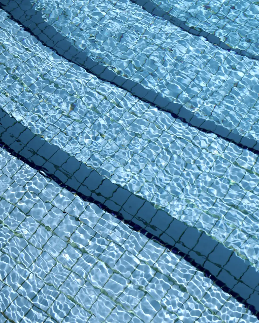 Close view of the tiled steps and rippled surface of a swimming pool